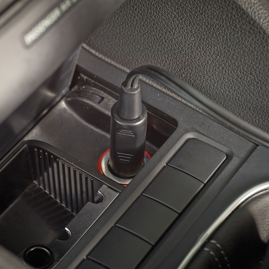 BLACKDECKER ADV1200 car vacuum power plug inserted in dashboard socket, close-up photography.