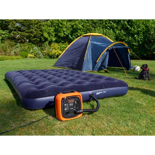 BLACKDECKER ASI400 air compressor inflating a navy air mattress outdoors near a tent, grass and dog visible.