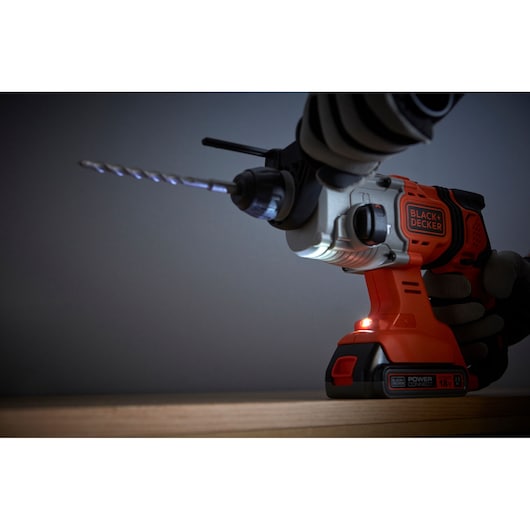 BLACK+DECKER BCD900E2K cordless hammer drill with LED light, close-up view during use.