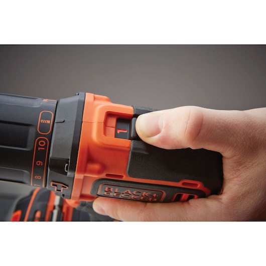 Close-up photo of a hand adjusting the speed setting on a BLACK+DECKER BDC718AS2F cordless drill.