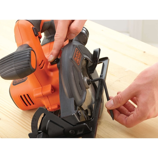 Photo of BLACKDECKER BDCCS18 cordless circular saw being adjusted with Allen wrench on wood surface.