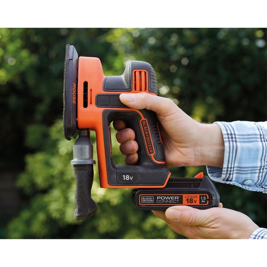 Photo of BLACK+DECKER 18V cordless sander BDCDS18 held in hand, showing side view and battery details.