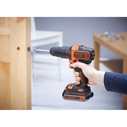 Photo of BLACKDECKER BDCHD18KB2 cordless drill with 18V lithium battery drilling into wooden door.