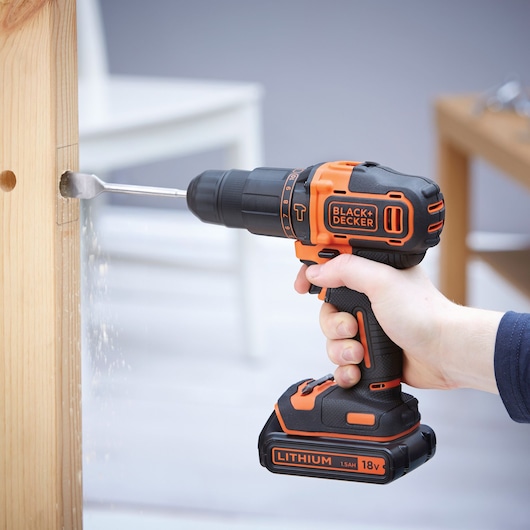 Photo of BLACKDECKER BDCHD18KB cordless drill being used to drill a hole in wood.