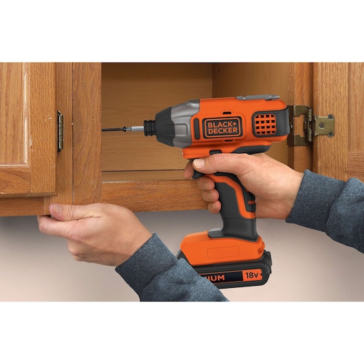 BLACKDECKER BDCIM18N impact driver used to install screw in wooden cabinet.