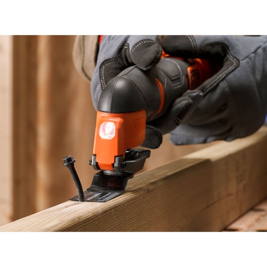 BLACKDECKER BDCOS18D1K oscillating tool cutting through wood plank, close-up photography.