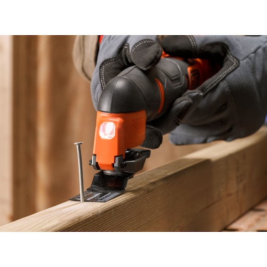 BLACKDECKER BDCOS18D1K cordless multi-tool cutting wood with a metal blade, close-up photo.