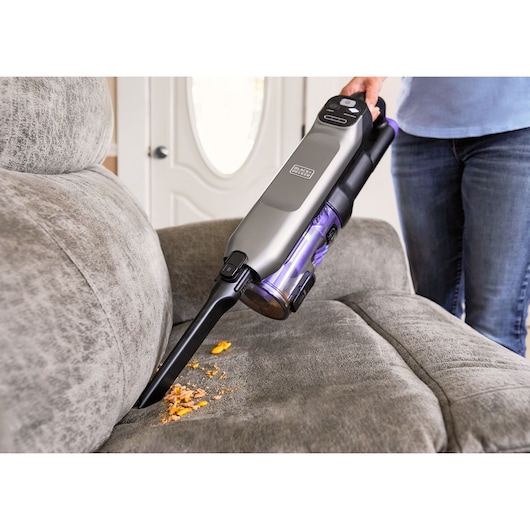 BLACKDECKER BHFEA640WG handheld vacuum cleaning sofa crumbs, close-up photography.