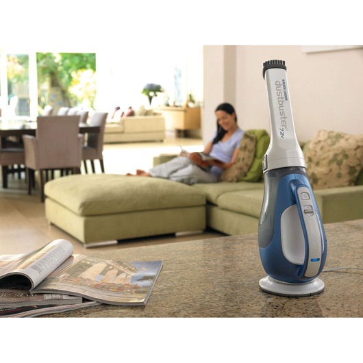 BLACKDECKER DV7210N handheld vacuum cleaner standing on a kitchen counter in a modern living room setting.