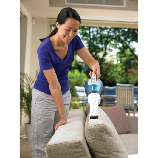BLACKDECKER DV7210N handheld vacuum cleaning couch upholstery indoors.