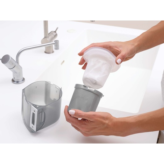BLACKDECKER DVJ325BFS vacuum filter and dust container near a sink, shown being cleaned.