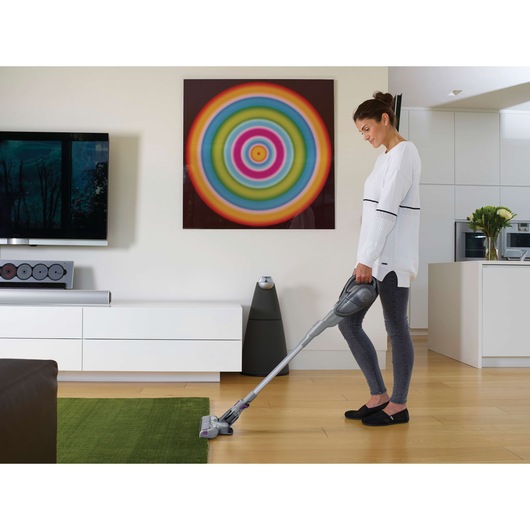 BLACKDECKER FEJ520JFS cordless vacuum used on green rug in modern living room.