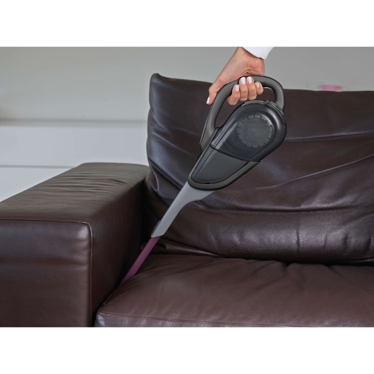 BLACKDECKER FEJ520JFS handheld vacuum cleaning between sofa cushions indoors.