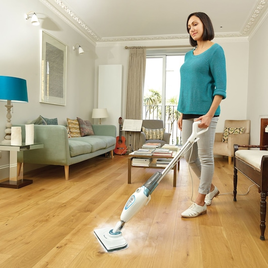 BLACKDECKER FSM1605 steam mop cleaning hardwood floor in living room setting, front angle.