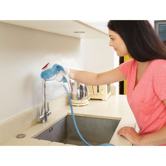 BLACKDECKER FSMH13101SM steam cleaner used on kitchen faucet, countertop view, photography.