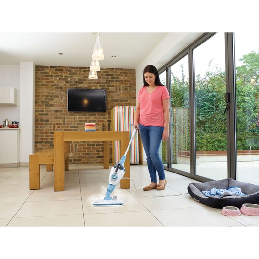 BLACKDECKER FSMH13101SM steam mop cleaning tiled floor in modern kitchen, woman holding handle.