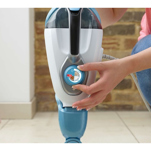 BLACKDECKER FSMH1351SM steam cleaner close-up, hand adjusting blue control dial.