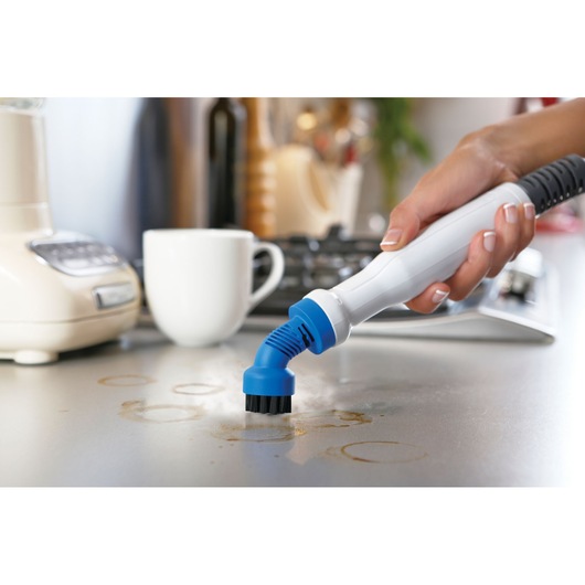 BLACKDECKER FSMH1351SM steam cleaner with blue brush attachment cleaning kitchen countertop.