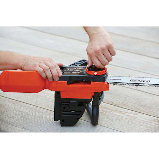 Photo of BLACKDECKER GKC1825LB chainsaw maintenance, person adjusting chain tension on wooden surface.