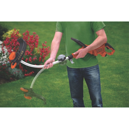 BLACKDECKER GL9035 grass trimmer in use, orange and black body, shown on garden lawn.