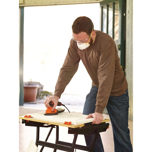 BLACKDECKER KA2000 sander used on wooden board in workshop setting.