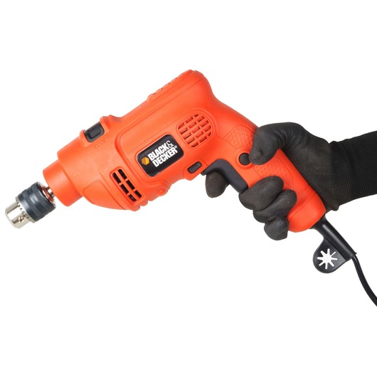 Photo of BLACKDECKER KR504RE-IN orange corded drill held by a gloved hand, side view, tool category.