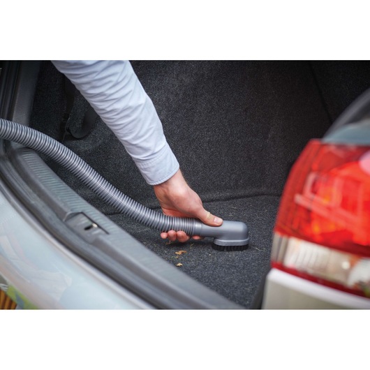 BLACKDECKER NV1210AV car vacuum cleaning trunk, flexible hose brush attachment, rear car view.