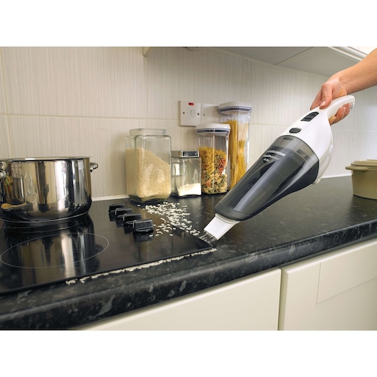 BLACKDECKER NV4820N handheld vacuum cleaning rice on kitchen counter, side angle.