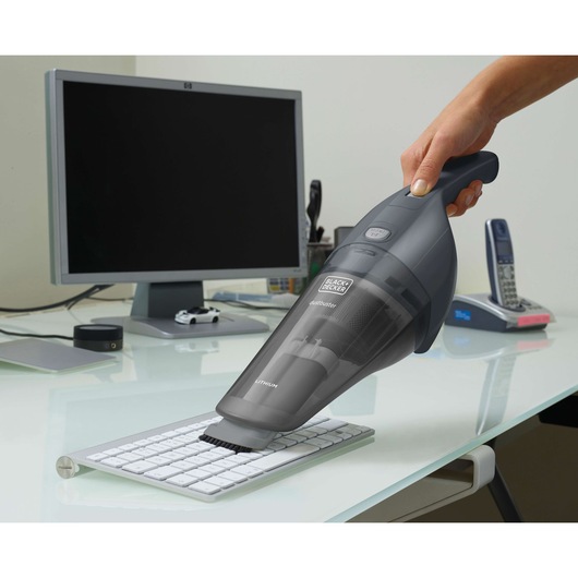 BLACKDECKER NVB215WA handheld vacuum cleaning keyboard on office desk