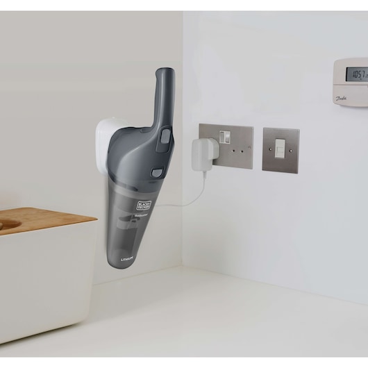 BLACKDECKER NVB215WA handheld vacuum on wall mount charging in a modern kitchen setting.