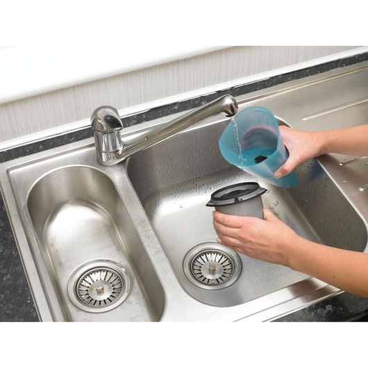 BLACKDECKER NW4820N vacuum filter being washed under a tap in a kitchen sink, close-up angle.