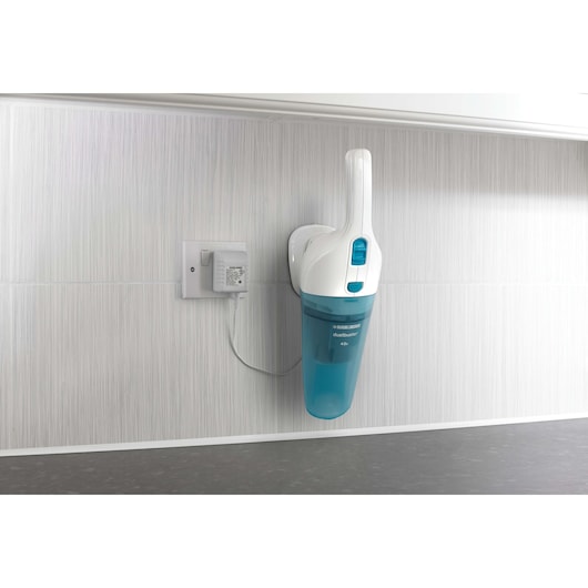 Photo of BLACK+DECKER NW4820N handheld vacuum cleaner in blue and white, wall-mounted and charging in kitchen.