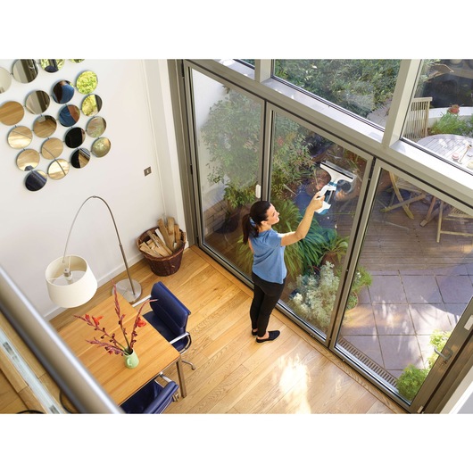 BLACKDECKER WW100 window vacuum cleaner used to clean glass doors in bright modern room.