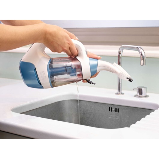 Photo of BLACKDECKER WW100 handheld vacuum cleaner being emptied over a sink.