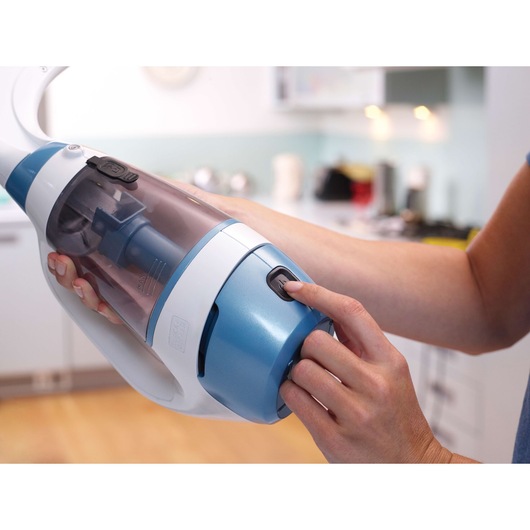 Close-up photo of BLACK+DECKER WW100 handheld vacuum cleaner with blue and white body in a kitchen setting.